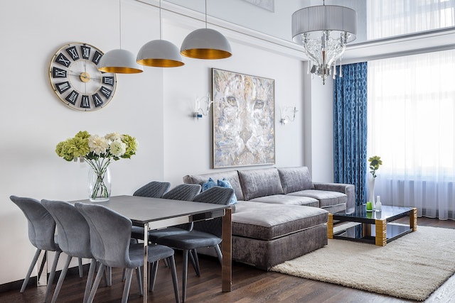 grey kitchen table and chairs next to living room with silver couch