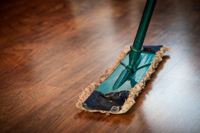 dark hardwood flooring being cleaned with a mop
