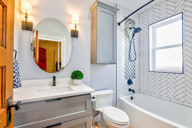 renovated bathroom with chevron tiles and storage under the vanity